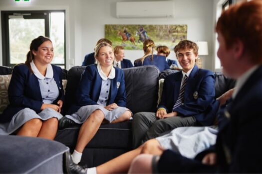 Male and female students socialising in the boarding common area.
